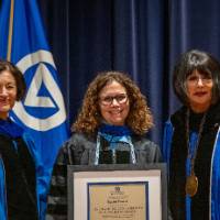 Provost and President take picture with woman on stage